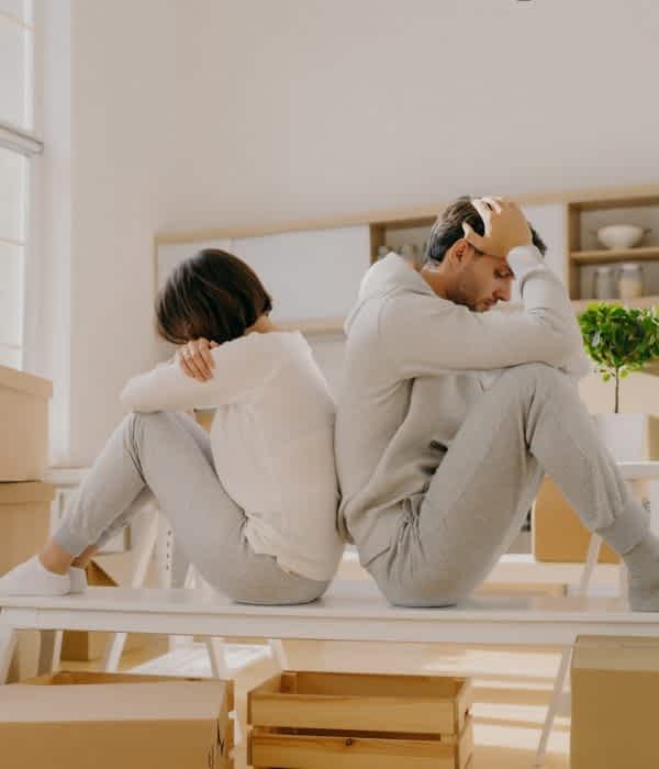 Stressful couple get divorce, leave house, start living separately, sit backs to each other,